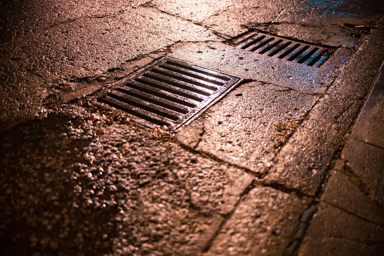 Metal Drainages on the Wet Asphalt Road